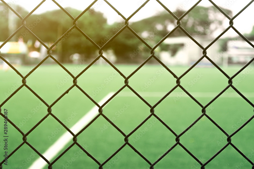 The iron grid fence of the football field in the evening The iron grid fence of the football field in the evening