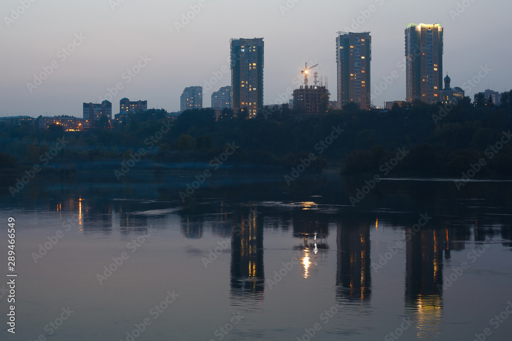 three buildings in the evening are reflected in the water three buildings in the evening are reflected in the water