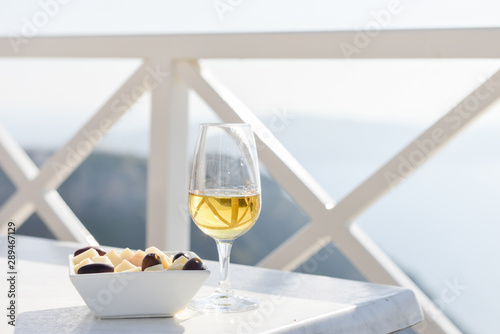 Wine and snack on table by Aegeon Sea photo