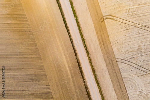 Machines ploughed dry farmlands, aerial landscape. Tractor tracks pattern