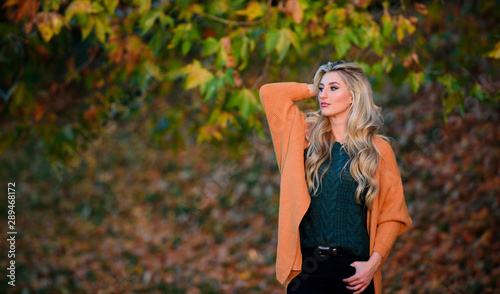 Cozy casual outfits for late fall. Cozy outfit ideas for weekend. Woman walk sunset light. Comfortable outfit. Girl adorable blonde posing in warm and cozy outfit autumn nature background defocused