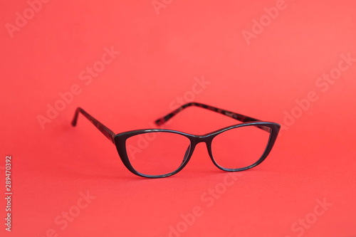 Fashionable stylish glasses on red background. Optics. Vision.