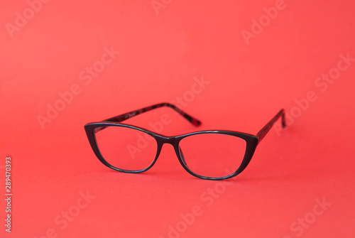 Fashionable stylish glasses on red background. Optics. Vision.