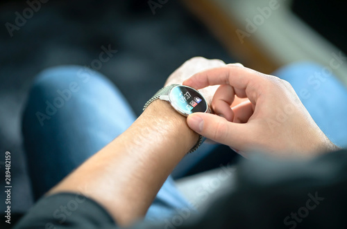 Smart watch, wearable gadget. Man wearing hybrid smartwatch. Wearables with digital touchscreen and mobile app technology. Person using wristwatch for business and work. Device with touch interface.