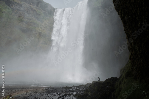 Big waterfall in Iceland with happy tourist
