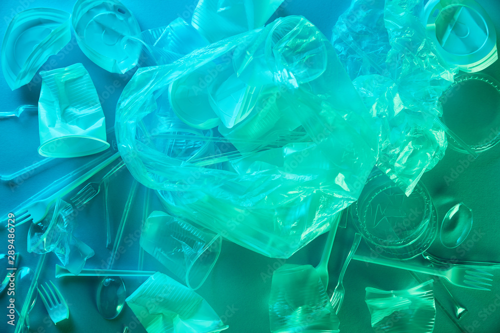 top view of crumpled plastic bags and cups in blue light top view of crumpled plastic bags and cups in blue light