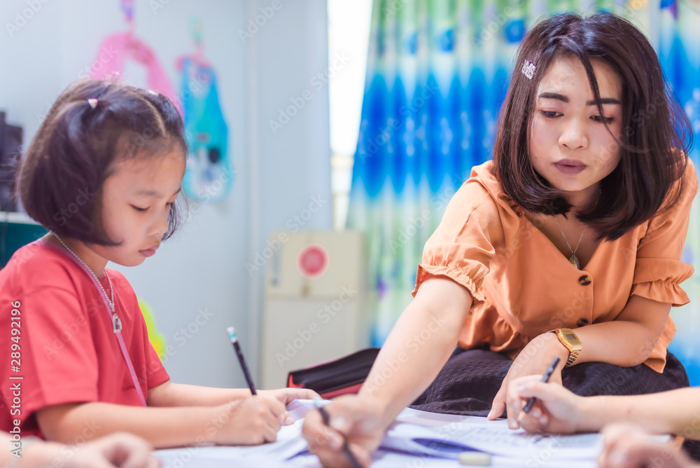 Asian elementary school girl is studying in the classroom with an Asian female teacher. Asian elementary school girl is studying in the classroom with an Asian female teacher.