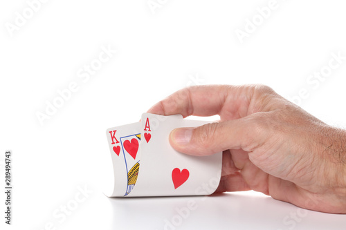 caucasian man's hand showing ace and king hearts poker cards isolated on white background with copy space for your text
