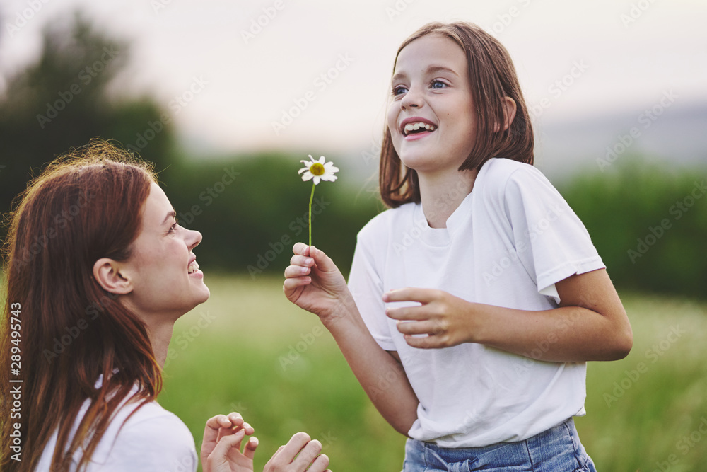 mother and daughter blowing soap bubbles in the park mother and daughter blowing soap bubbles in the park