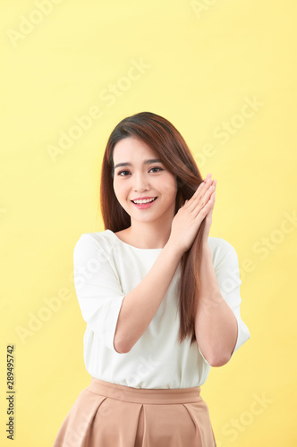 Beauty woman touch her long hair isolated on yellow background, asian beauty