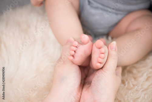 Close-up of the feet of a baby and of her mother
