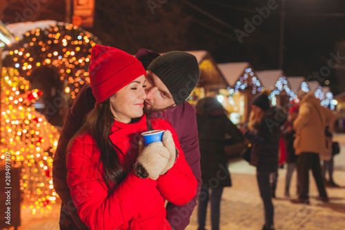 Man and woman embracing, having fun at Christmas fair