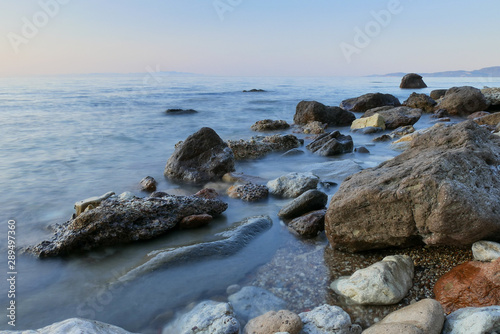 Long exposure image of Dramatic sky seascape with rock in sunset scenery background © Eline