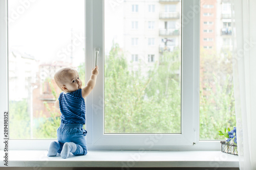Little boy on the windowsill, danger in the home
