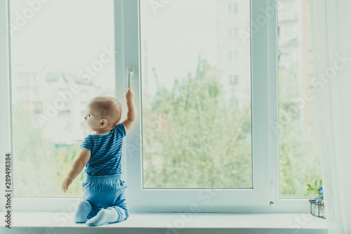Little boy on the windowsill, danger in the home