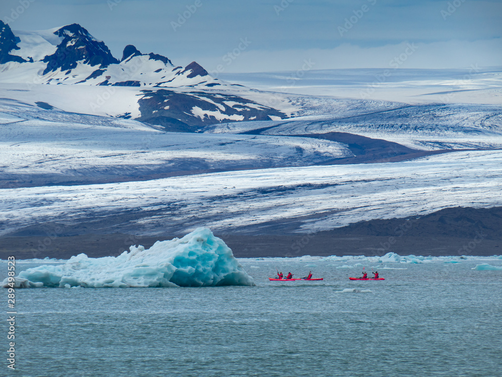 A group of friends in red kayaks near the Jökulsárlón glacier lagoon