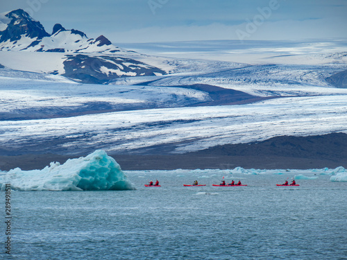 A group of friends in red kayaks near the Jökulsárlón glacier lagoon.