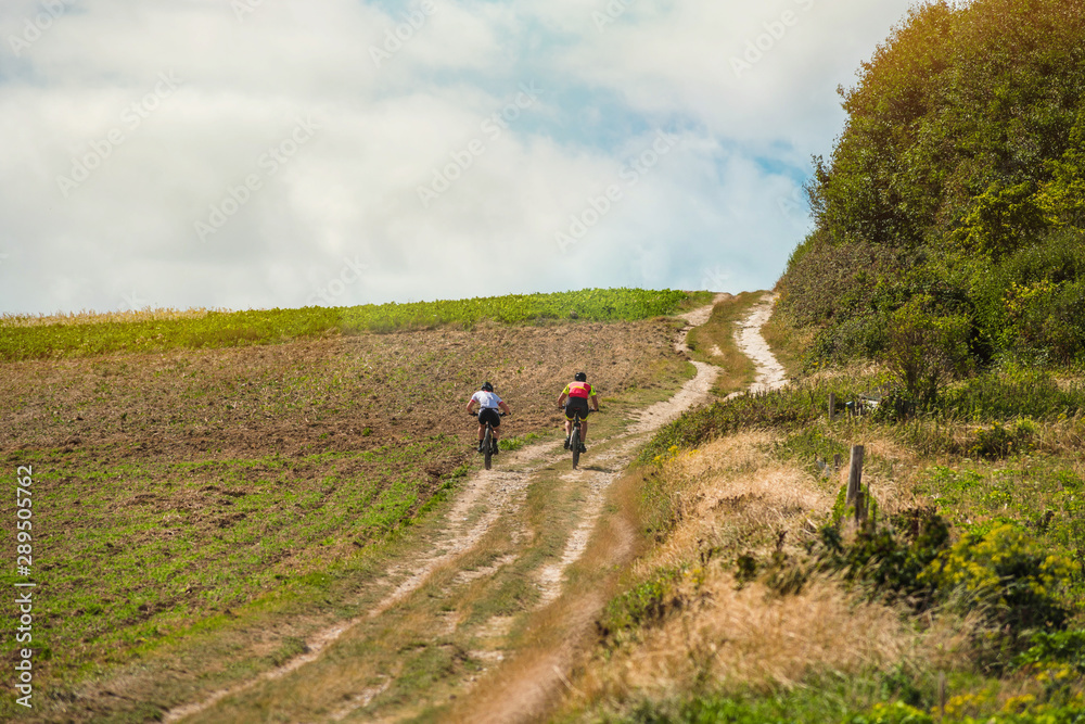 two cyclists riding mountain bike in the countryside