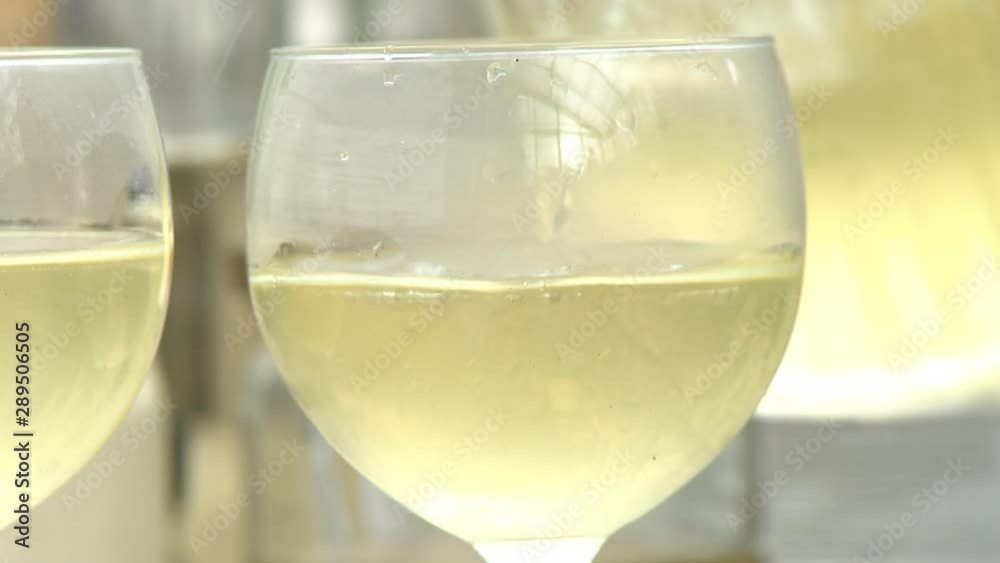 Extreme close up of a wine glass as white wine is poured into it Extreme close up of a wine glass as white wine is poured into it