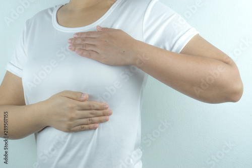 Woman hands doing breast self-exam for checking lumps and signs of breast cancer on white background. Health care and medical concept.