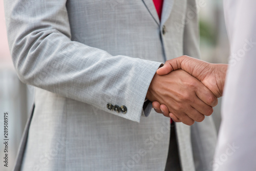 Business people in formal suits shaking hands. Business man greeting colleague. Handshake concept