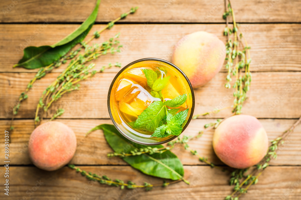 Tasty peach tea in glass on the rustic background. Selective focus. Shallow depth of field.