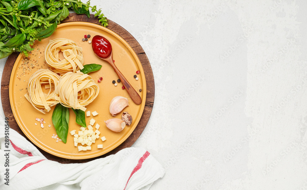 Ingredient for simple italian dinner on yellow plate. Fettuccine, fresh basil, tomato souce and mozzarella cheese