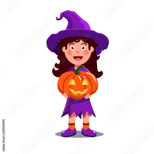 Girl in halloween witch costume holding pumpkin