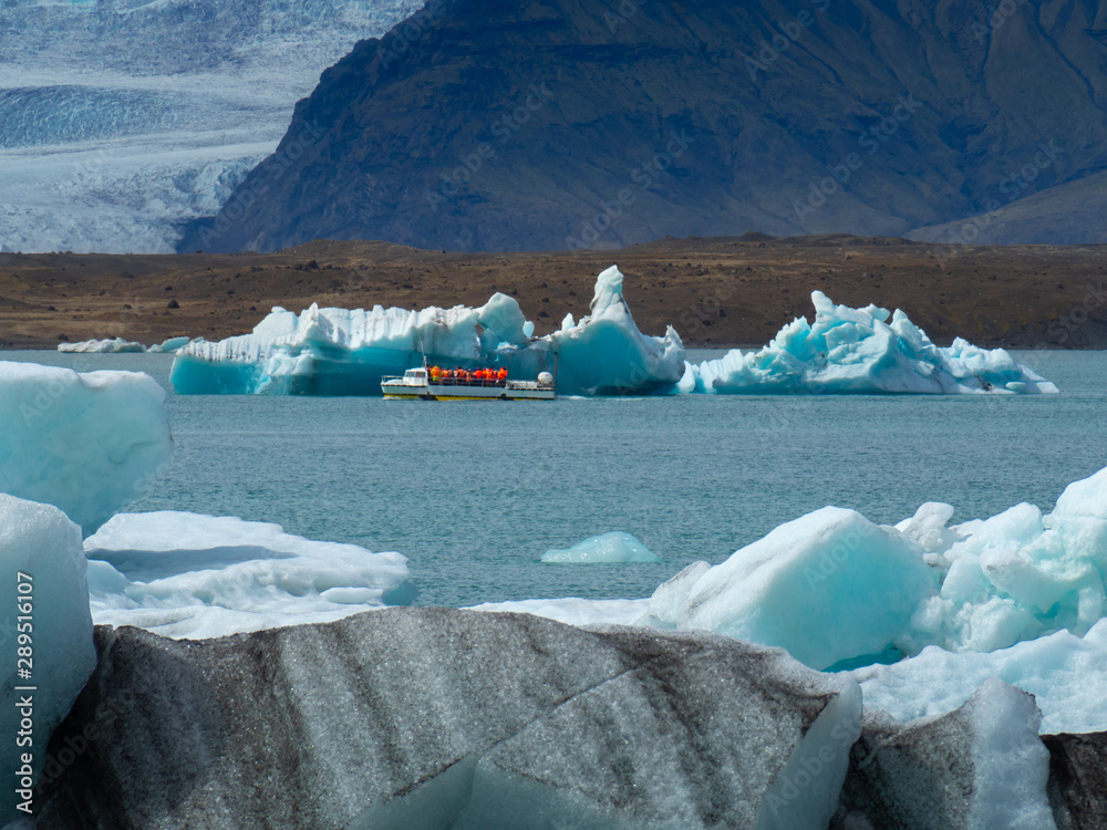 The tourist ship with tourists flows around Jökulsárlón Lake