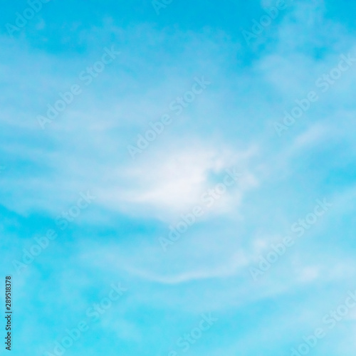 Abstract background of a vibrant clear blue sky with soft white clouds, square photo