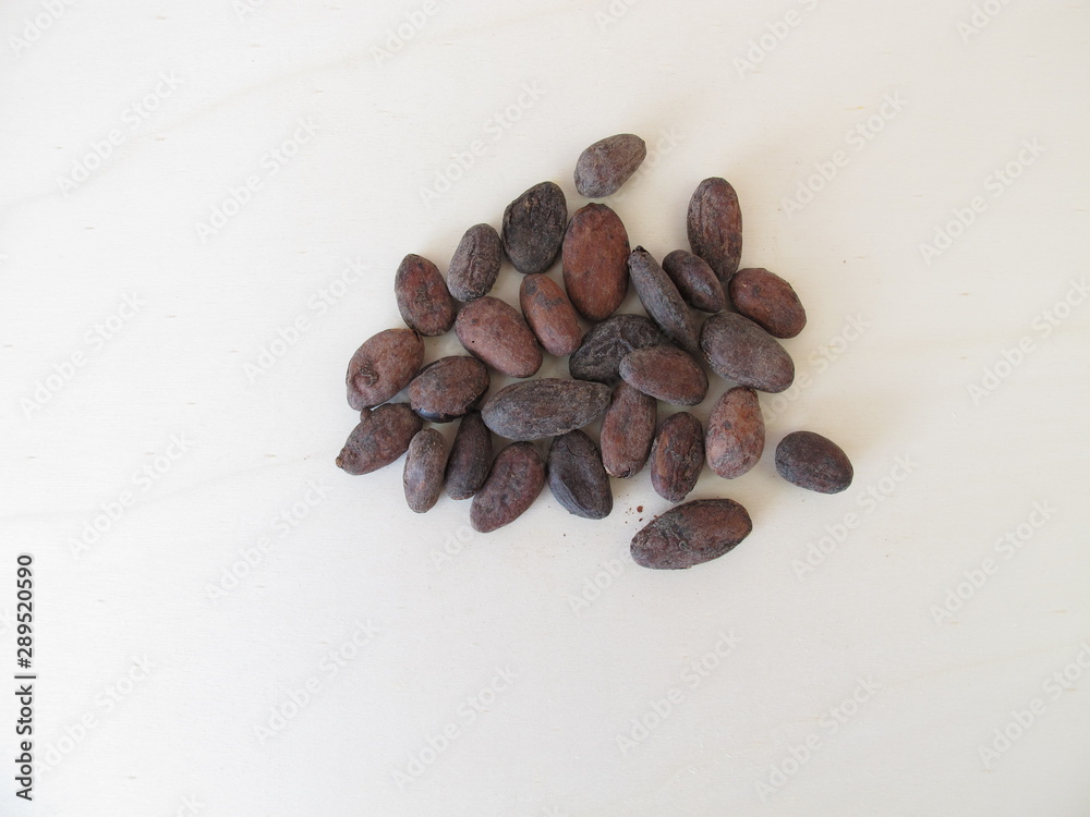 Obraz premium Roasted cocoa beans on a wooden board