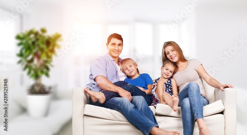 Young family at home smiling at camera