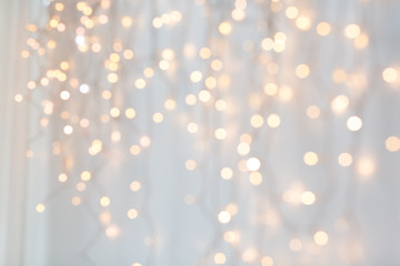 holiday, illumination and decoration concept - bokeh of christmas garland lights over grey background