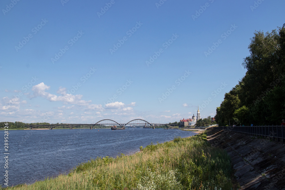 Naklejka premium Rybinsk. View of the building of the grain exchange, the Holy Transfiguration Cathedral and the bridge over the Volga river. View from the river
