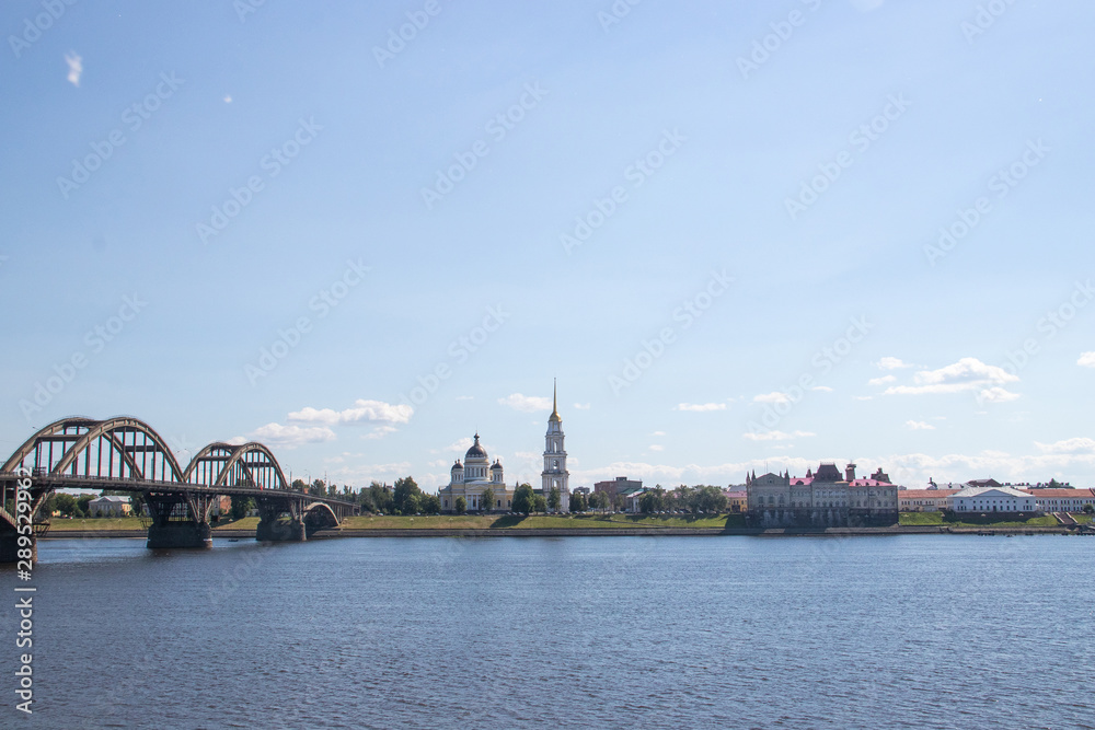Rybinsk. View of the building of the grain exchange, the Holy Transfiguration Cathedral and the bridge over the Volga river. View from the river