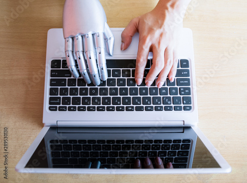 Robot hands and fingers point to laptop button advisor chatbot robotic artificial intelligence concept photo