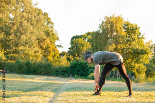 Sports and yoga. A man with a beard, in sportswear doing sports in the Park