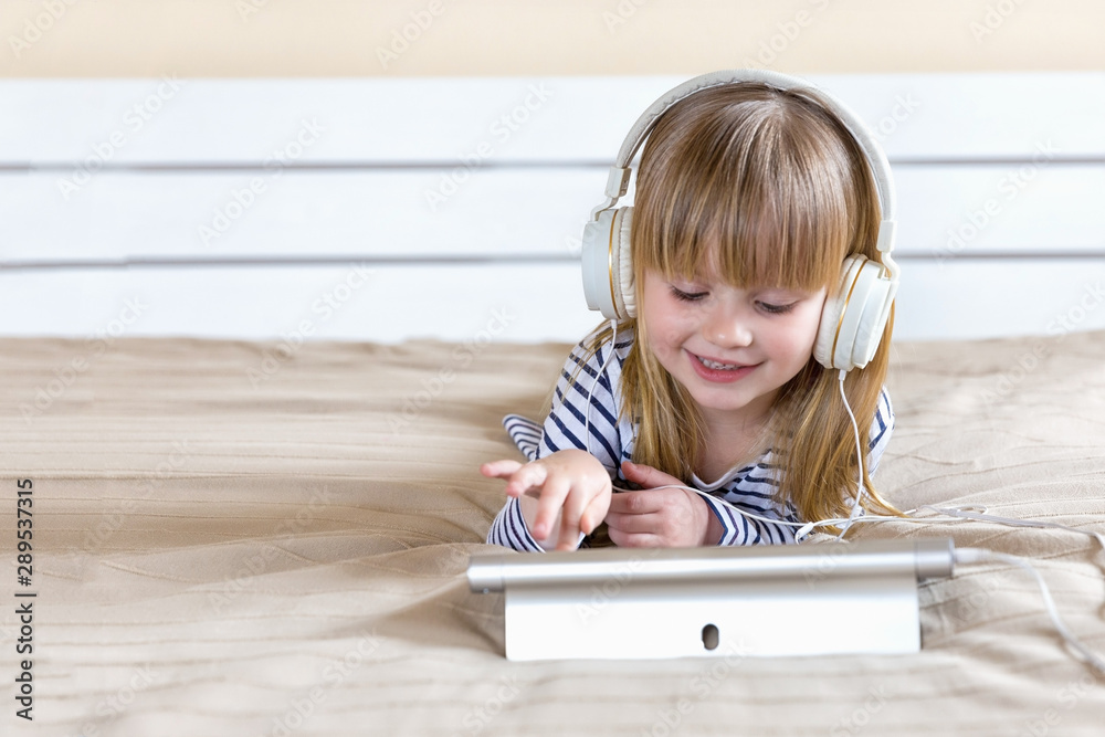 Portrait of little girl with headphones and laptop Portrait of little girl with headphones and laptop
