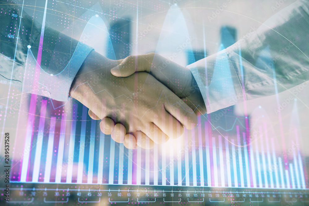 Double exposure of financial graph on cityscape background with two businessman handshake. Concept of stock market deal