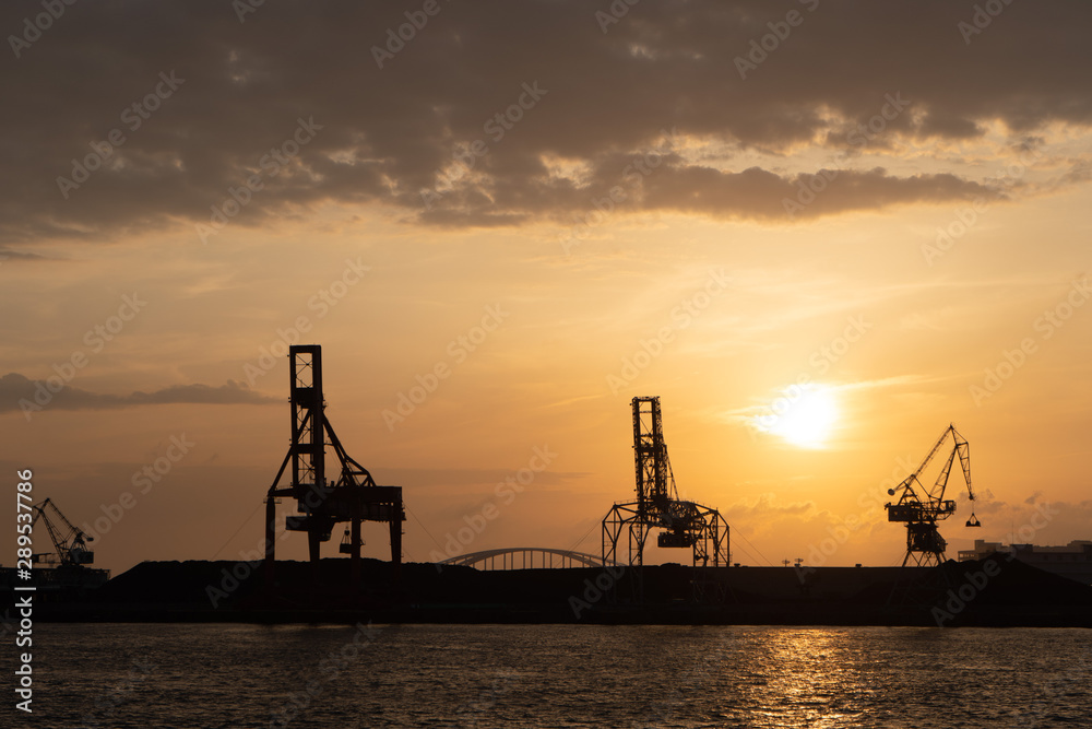 Port cranes silhouette at sunset in Osaka Japan
