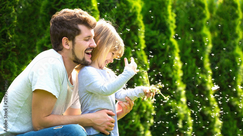 Daughter and her father have fun in summer garden