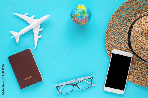 travel objects and accessories on blue background with passport and plane.