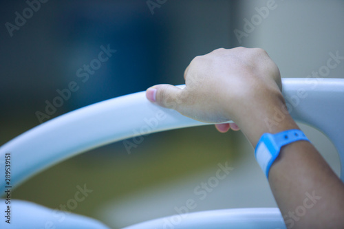 Patient's hand with a modern hospital bed, hospital room and medical equipment