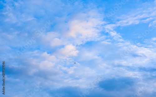 airplane fly on blue sky white fluffy cloud