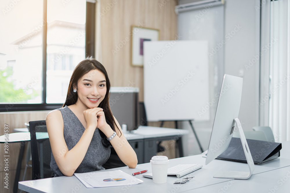 Portrait of beautiful happy smiling young businesswoman working on her computer in the office.,sitting on workplace.,Happy working. Portrait of beautiful happy smiling young businesswoman working on her computer in the office.,sitting on workplace.,Happy working.