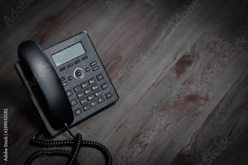 Closeup ip phone black color on the wood floor, Bussiness connection concept