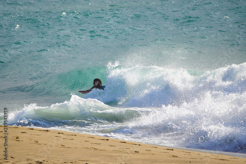 A black man caught a wave on the bodyboard of the Atlantic Ocean.