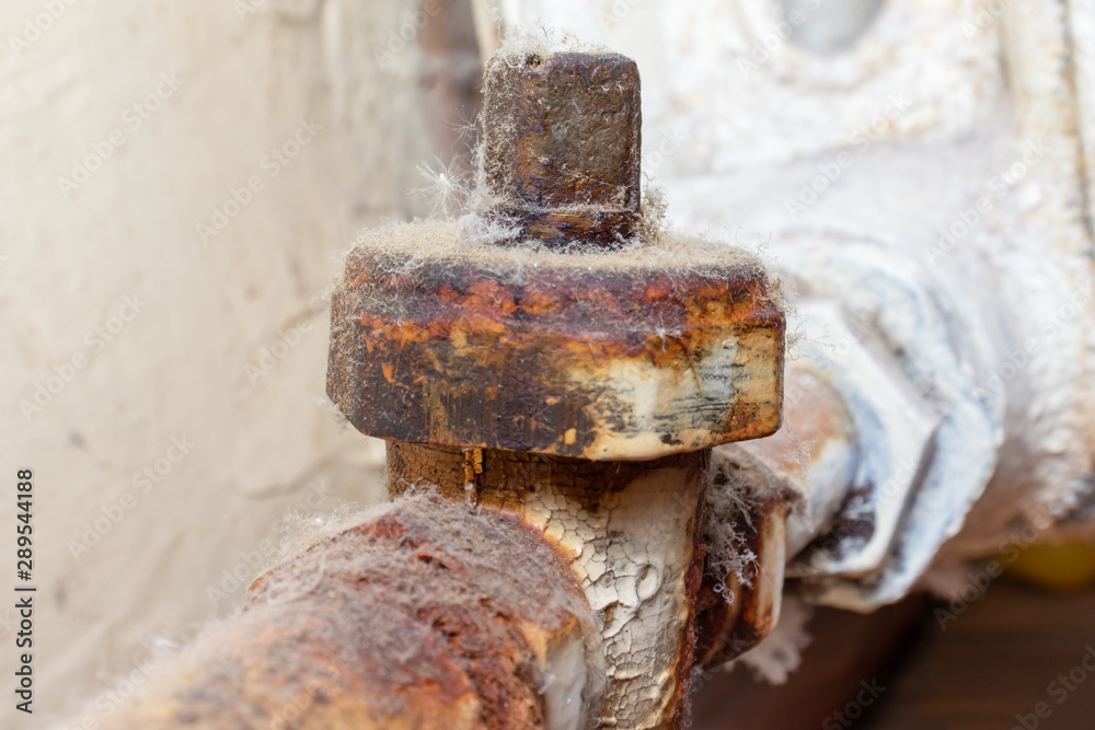Old broken rusty heating valve on a rusty pipeline of heating battery need to be repared or replaced by the plumber Old broken rusty heating valve on a rusty pipeline of heating battery need to be repared or replaced by the plumber
