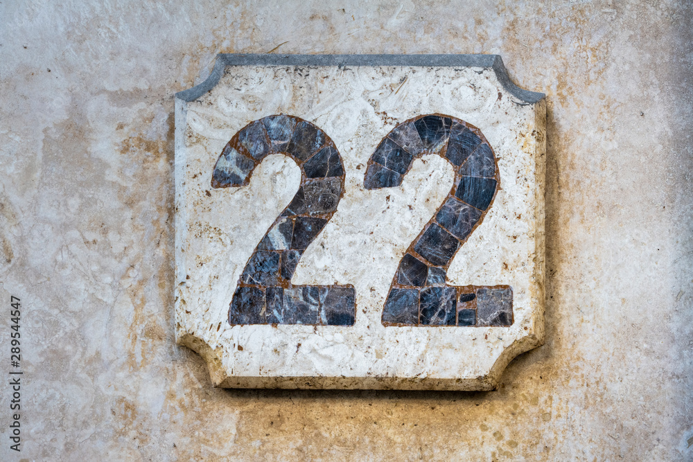Number 22, twenty two, street number sign on the wall Number 22, twenty two, street number sign on the wall