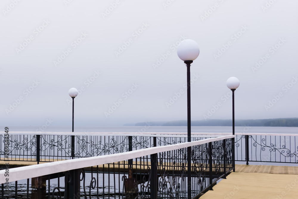 Naklejka premium foggy pier with lanterns